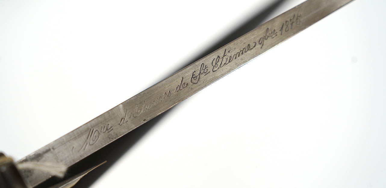 An 1875 French T-section bayonet in its steel scabbard for a Gras rifle, with engraving in French to the top of the blade. Condition - good